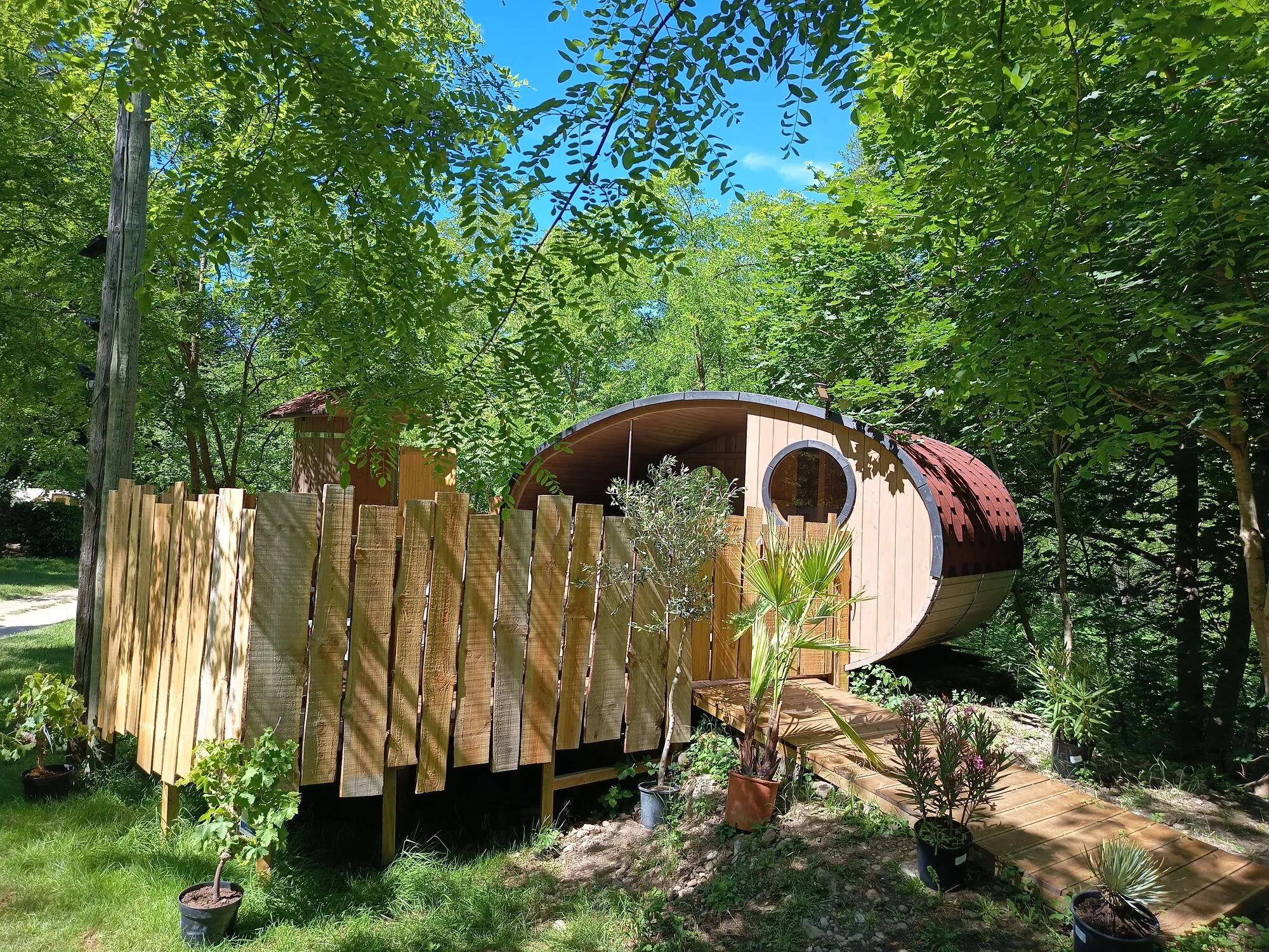 L'ellipse en bois du spa et du sauna, nichée dans les arbres